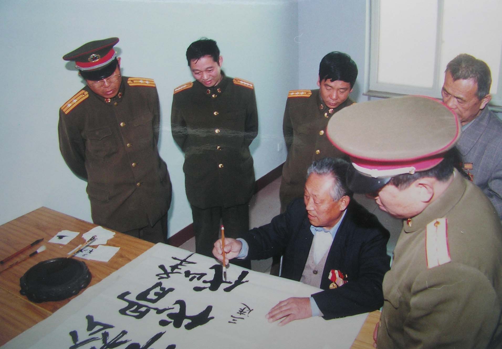 2001年4月3日马玉祥回原部队为335团提写松骨峰精神，代代相传。胡志国摄.jpg